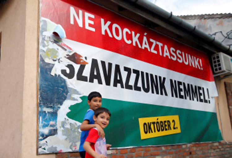 Hungarian Roma boys walk in front of the Hungarian goverment's poster regarding referendum on EU migrant quotas in Budapest, Hungary, September 28, 2016. Picture taken September 28, 2016. The poster reads: "We should not take a risk, vote no". REUTERS/Laszlo Balogh